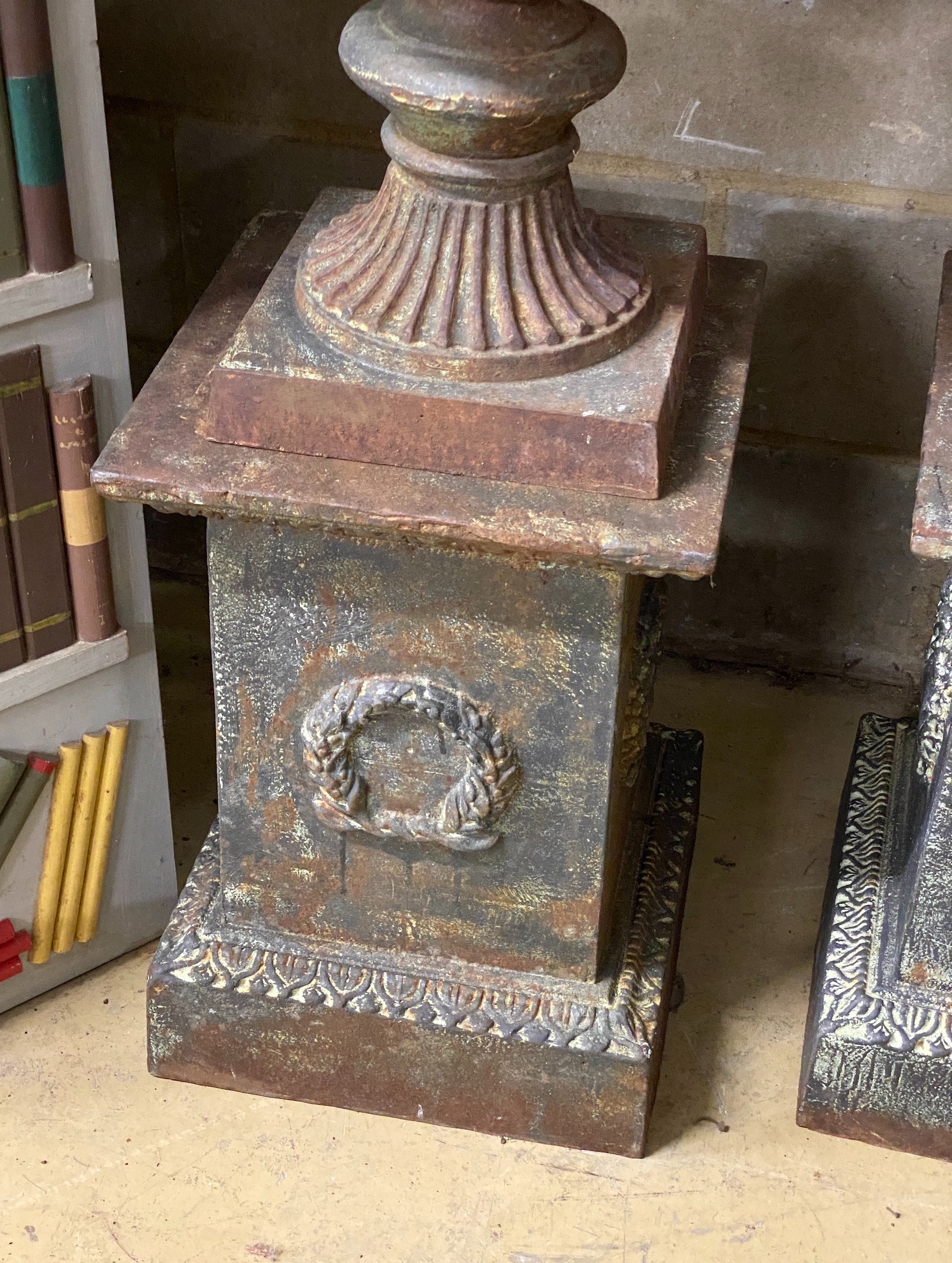 A pair of Victorian style cast iron campana garden urns on square plinths, height 110cm